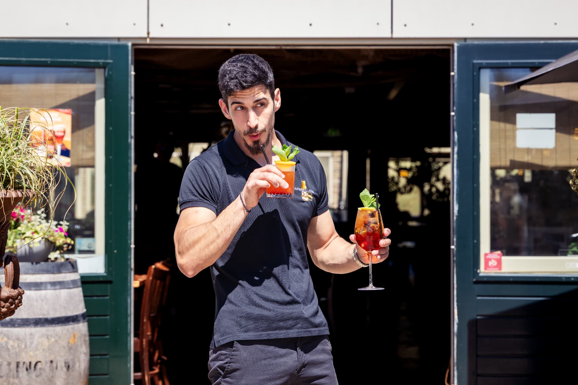 Staff member with cocktails at the entrance of Paal 28